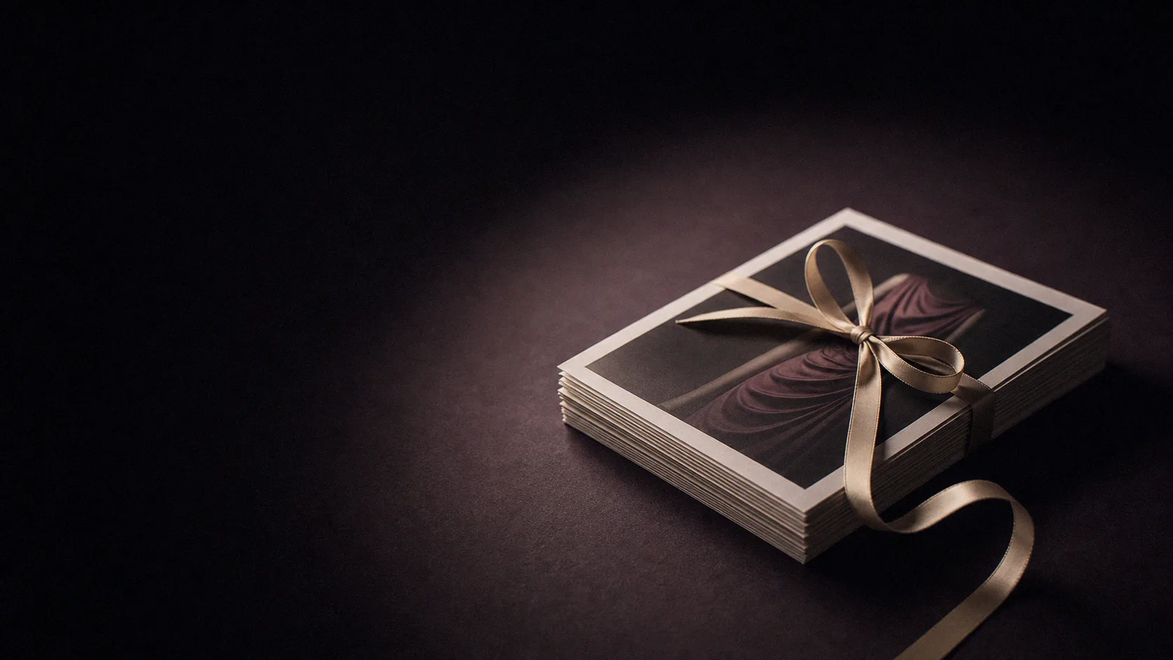 Stack of printed reports bound with a ribbon on a dark surface